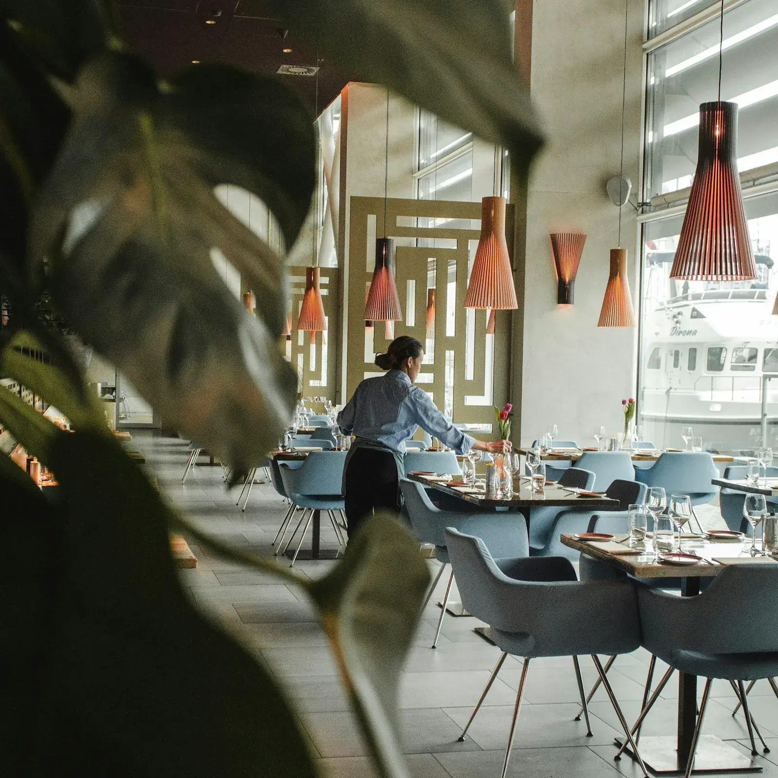Gastgeberin vor Tischen in einem Restaurant